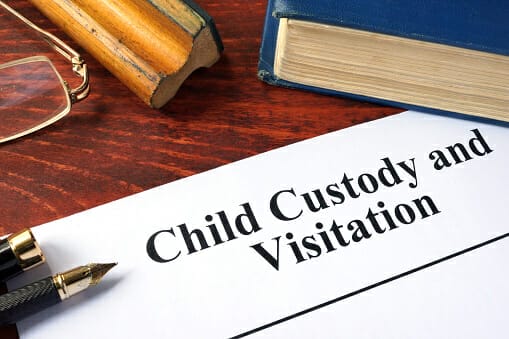 Child Custody and Visitation written on a paper and a book.